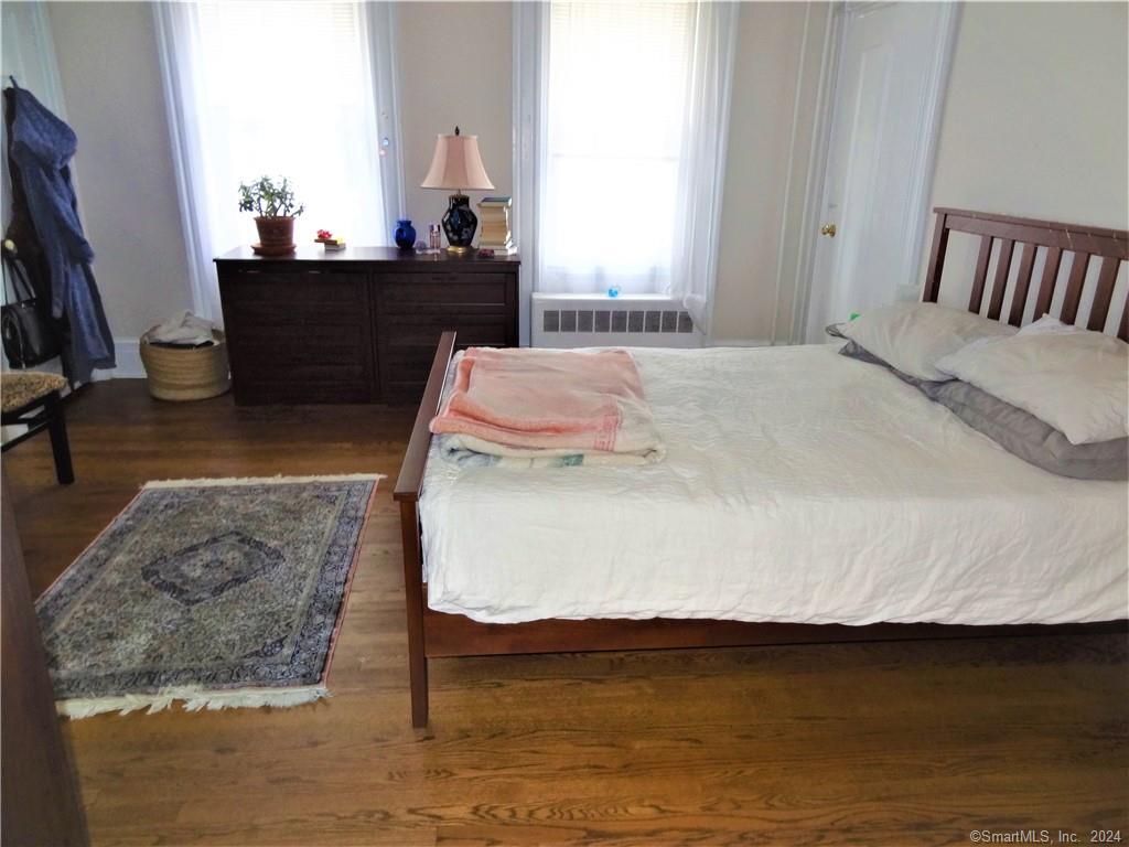 237 Brewster Street Bridgeport, CT 06605 - Photo 5 of 23 a bed sitting in a bedroom next to a window with a flat screen tv