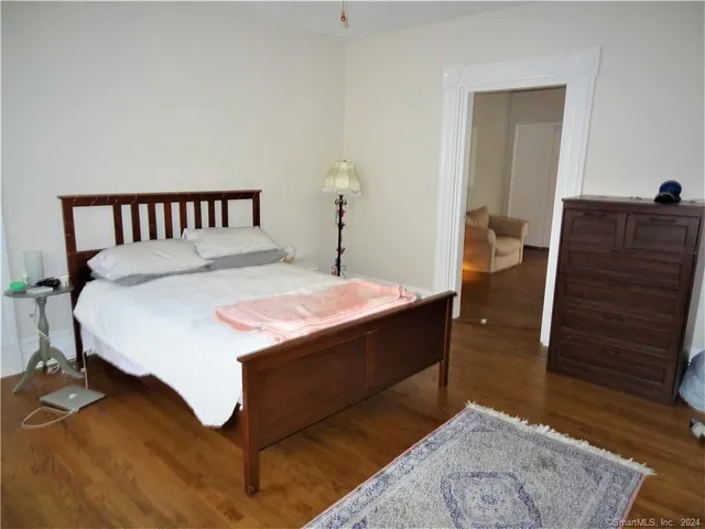 a bed sitting in a bedroom next to a wooden cabinet
