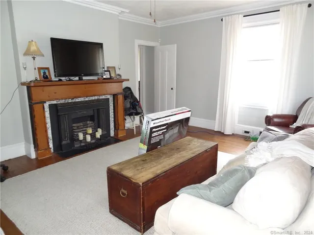 a living room with furniture a flat screen tv and a fireplace