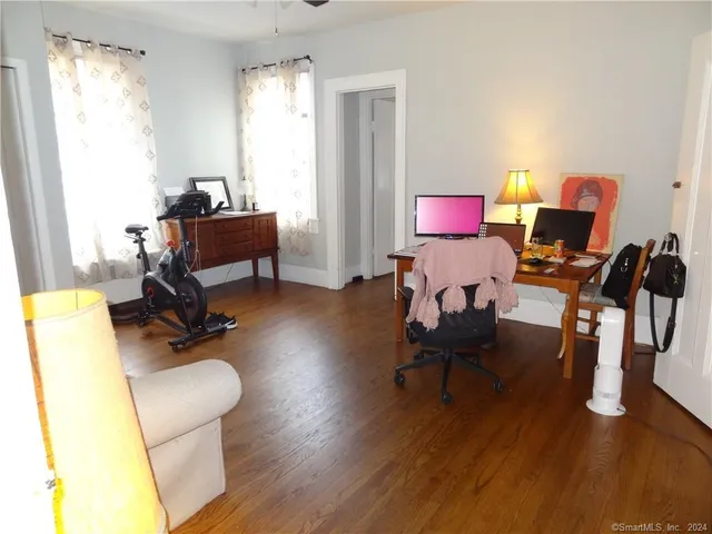 a view of a workspace with furniture and a window