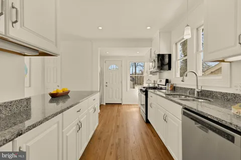 a large kitchen with stainless steel appliances granite countertop a lot of counter space and a sink