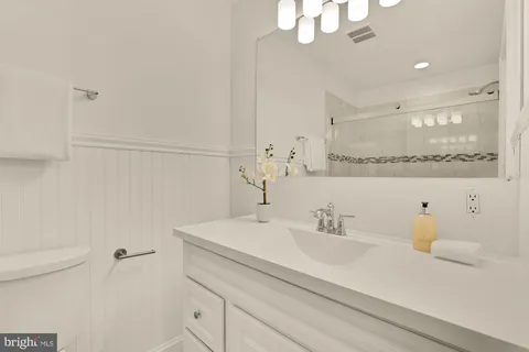 a bathroom with a sink a toilet and a mirror
