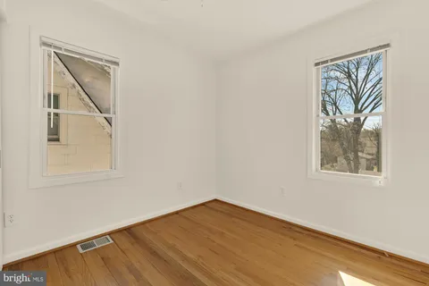 an empty room with a window and wooden floor