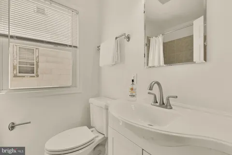 a bathroom with a sink a toilet and mirror