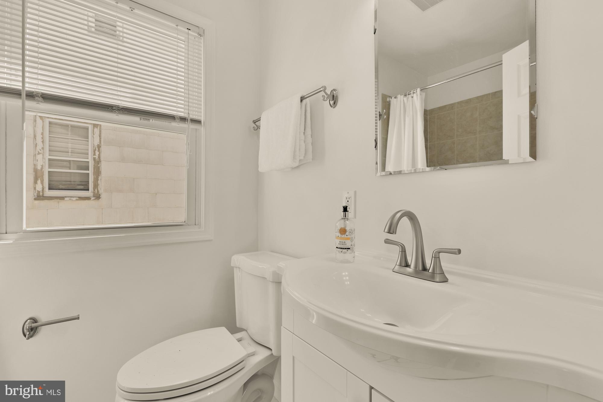 2425 Perry Street Northeast Washington, DC 20018 - Photo 26 of 43 a bathroom with a sink a toilet and mirror