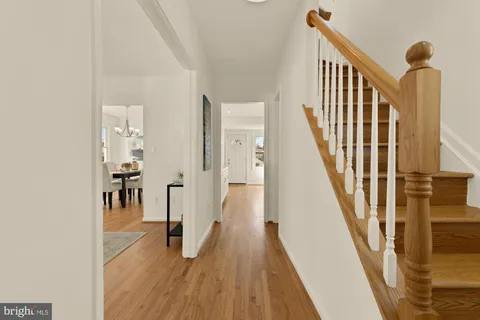 a view of a hallway with wooden floor and staircase