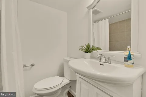 a bathroom with a sink a toilet and a mirror