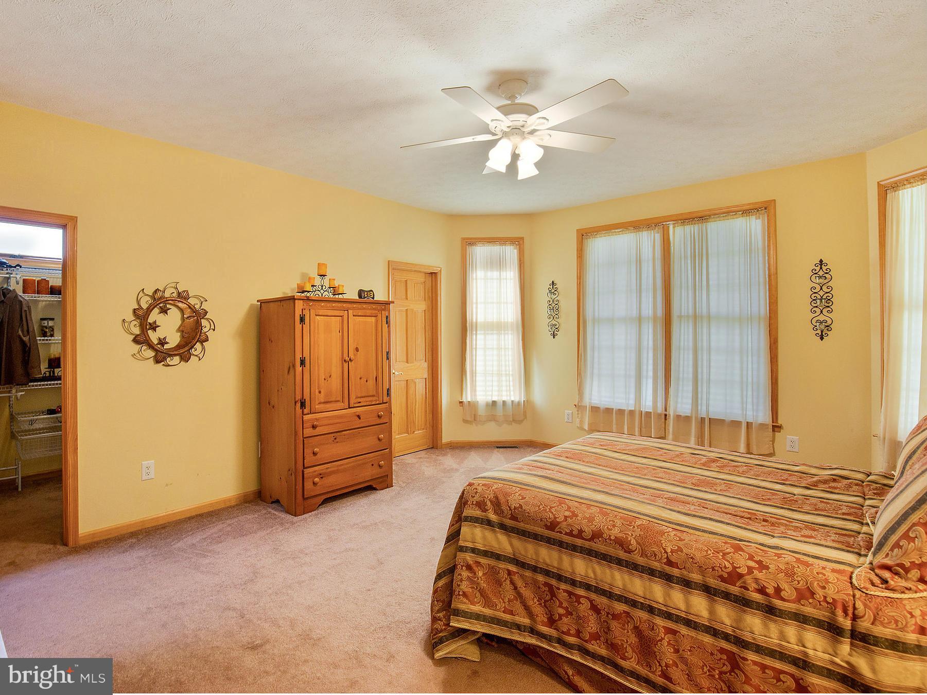 48510 Whitaker Road St. Inigoes, MD 20684 - Photo 14 of 30 a bedroom with a bed and a chandelier