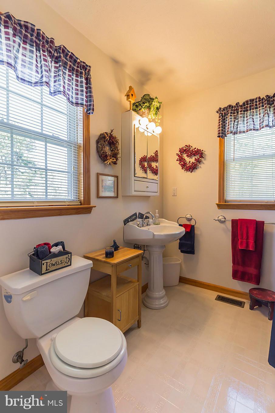 48510 Whitaker Road St. Inigoes, MD 20684 - Photo 26 of 30 a bathroom with a toilet sink and mirror