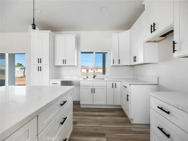 a kitchen with granite countertop white cabinets white stainless steel appliances and sink