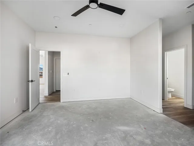 an empty room with closet and fan