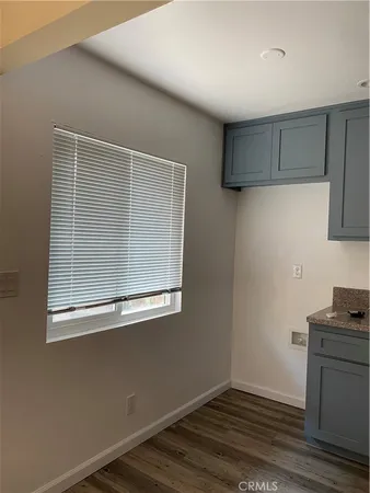 a view of empty room with wooden floor and cabinet