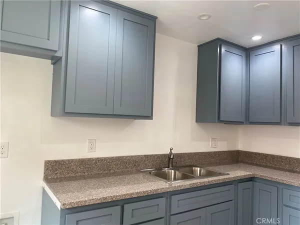 a kitchen with granite countertop a sink and cabinets