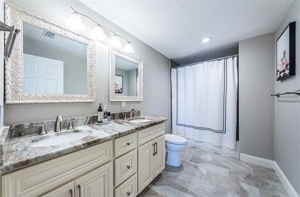 a spacious bathroom with a granite countertop sink and a mirror