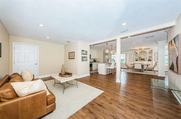 a living room with furniture and view of kitchen