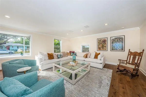 a living room with furniture and a wooden floor