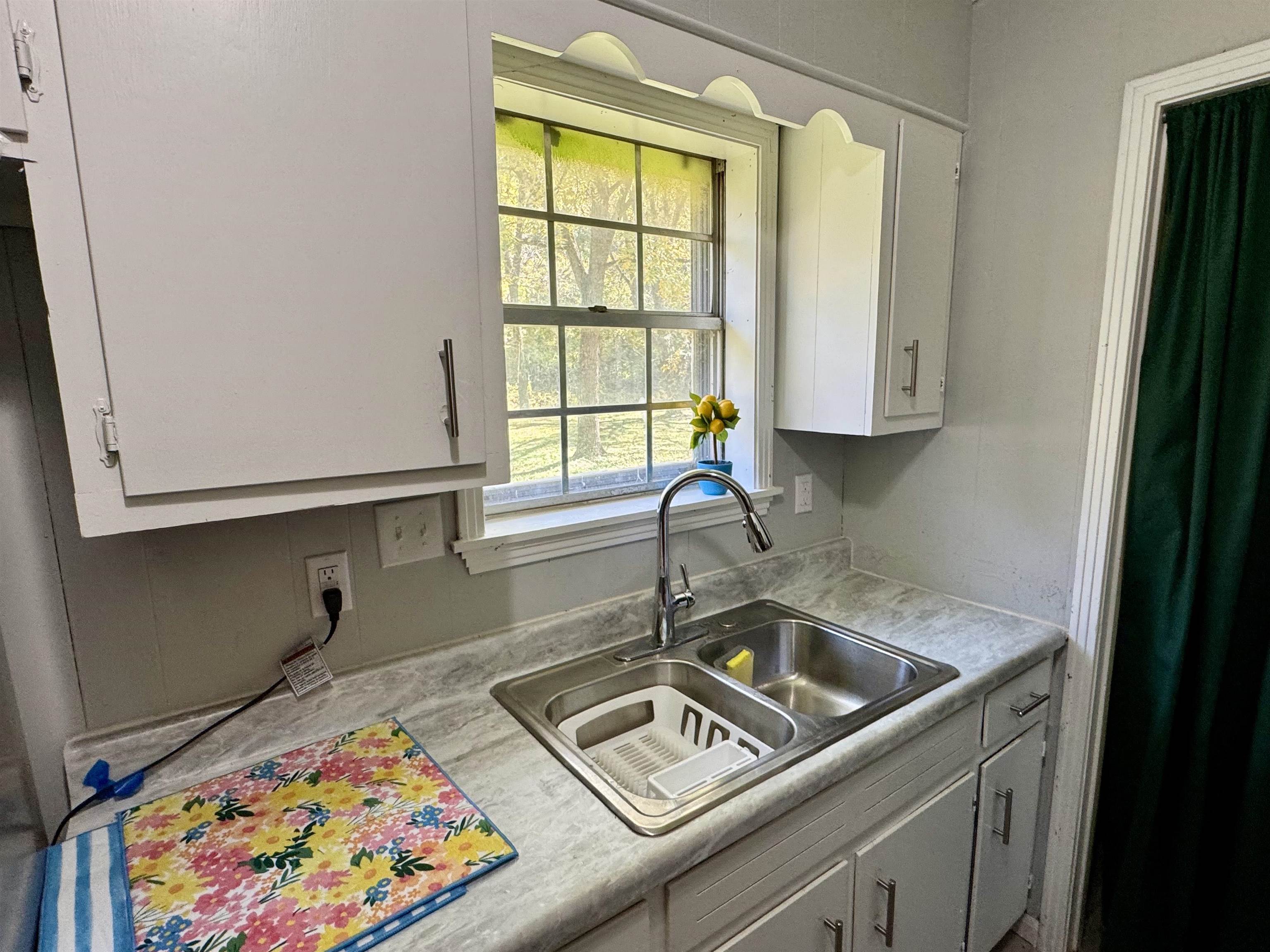 7692 Currie Road Millington, TN 38053 - Photo 3 of 13 a kitchen with a sink cabinets and a window