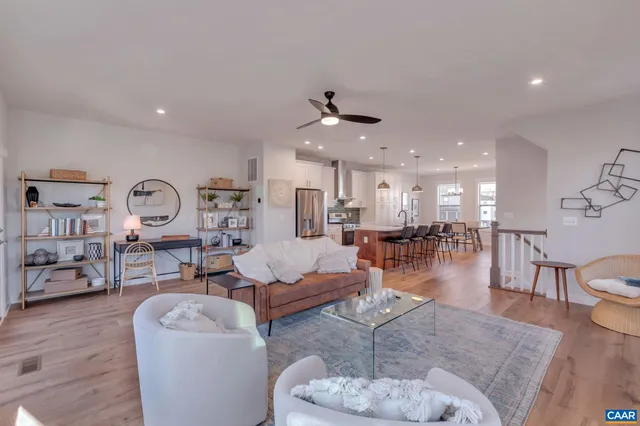 a living room with furniture a rug and kitchen view