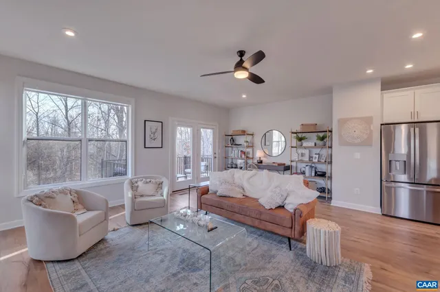 a living room with furniture fireplace and a large window