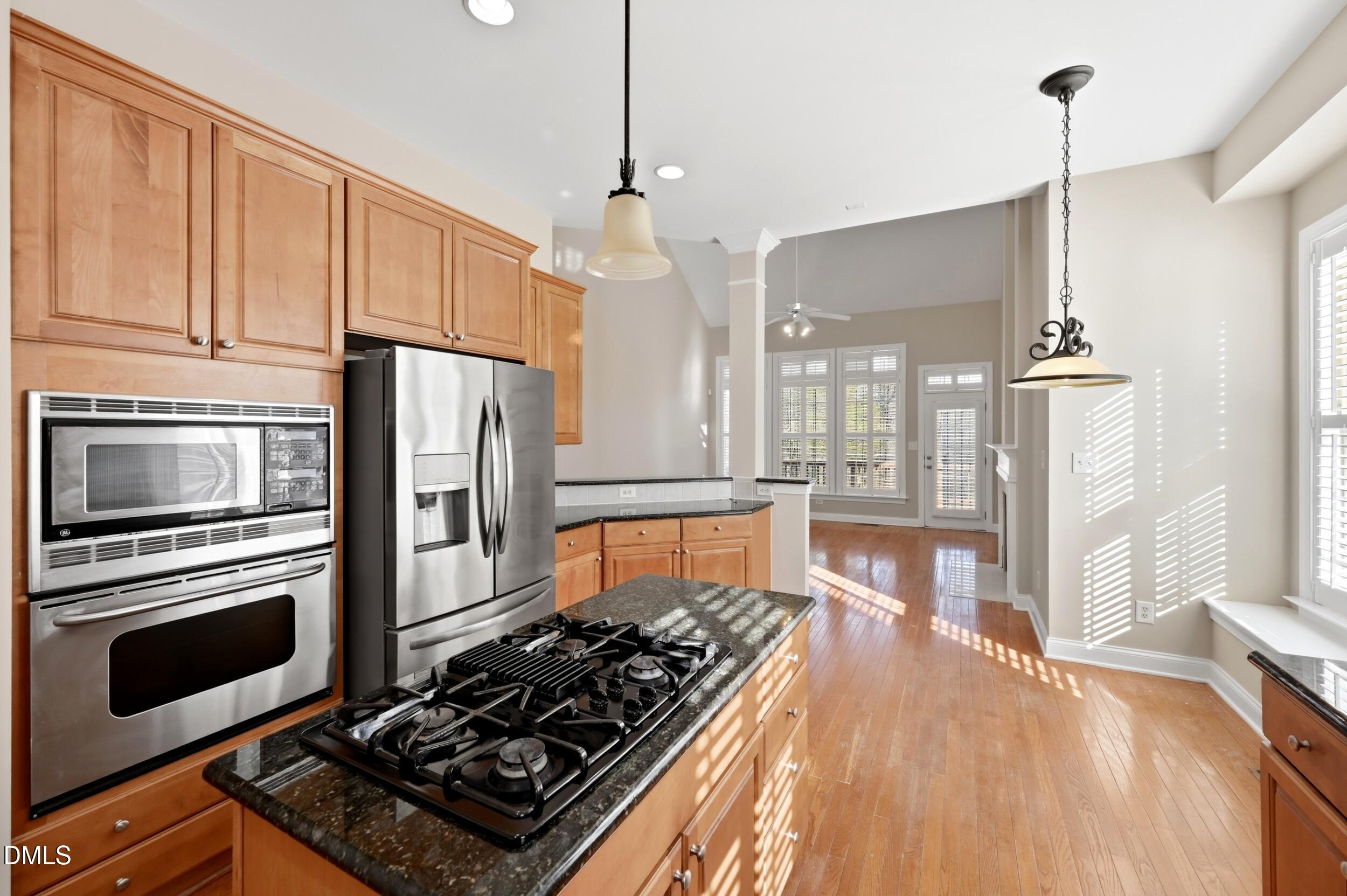 4803 Marena Place Durham, NC 27707 - Photo 9 of 42 a kitchen with granite countertop a stove and a wooden floors