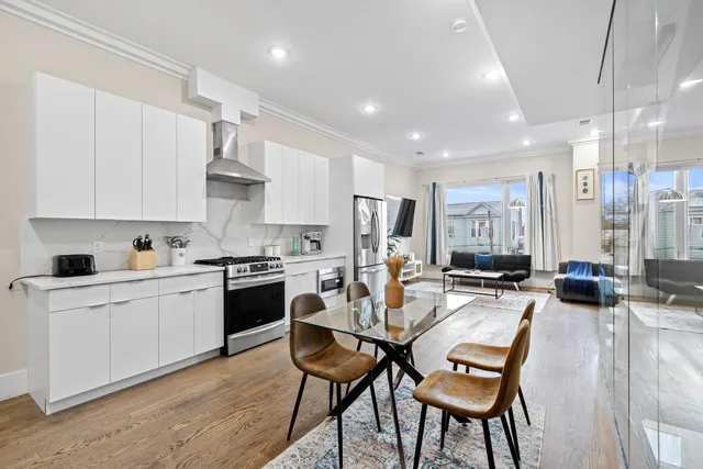 a kitchen with stainless steel appliances kitchen island granite countertop a stove a sink a dining table and chairs