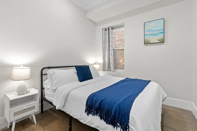 a bedroom with a bed and a painting on the wall