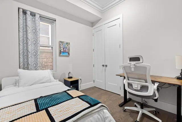 a bedroom with a bed and a desk