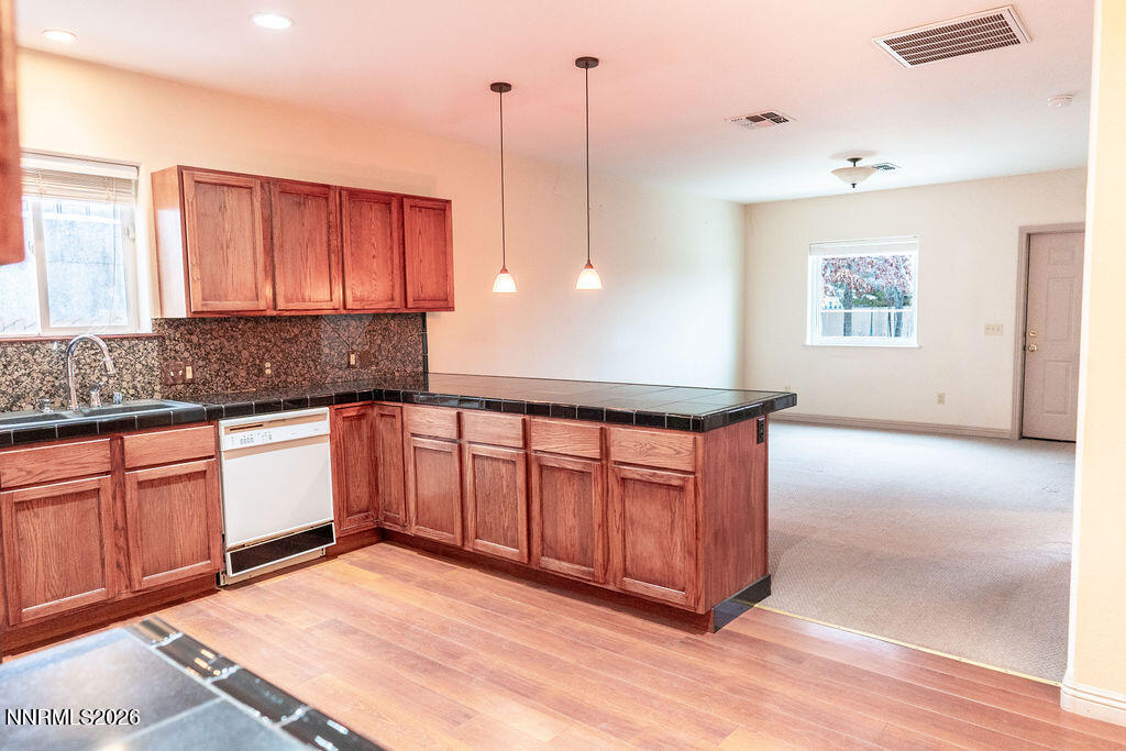 2931 Airport Road Carson City, NV 89706 - Photo 9 of 35 a kitchen with stainless steel appliances granite countertop a stove a sink and white cabinets with wooden floor