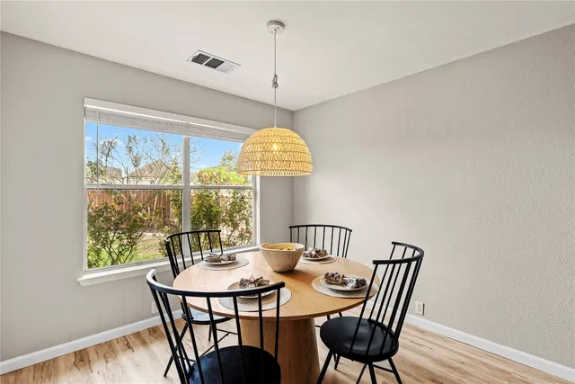 a kitchen with stainless steel appliances granite countertop a dining table chairs and a stove top oven