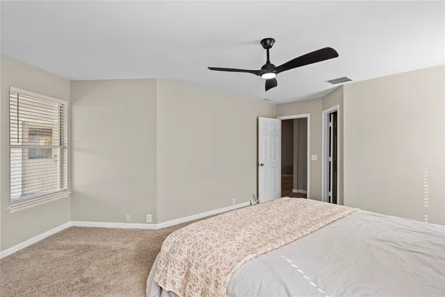 a bedroom with a large bed and a ceiling fan