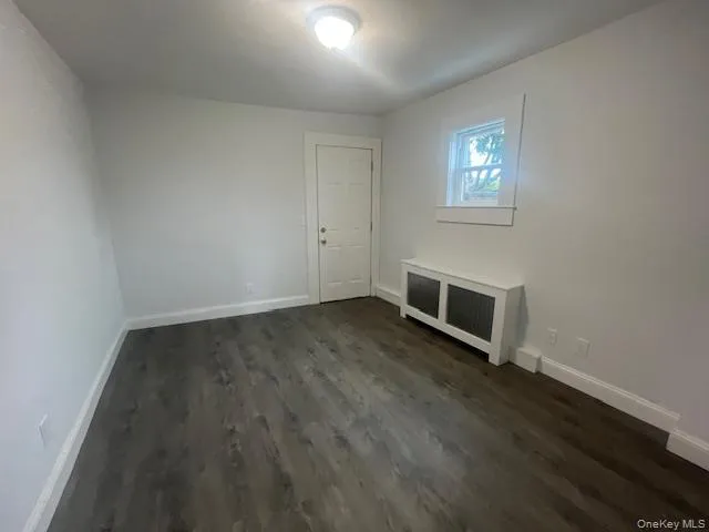 a view of a livingroom with wooden floor and a window