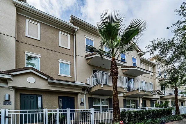 a front view of a house with a tree