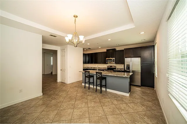 a kitchen with stainless steel appliances granite countertop a refrigerator and a stove top oven