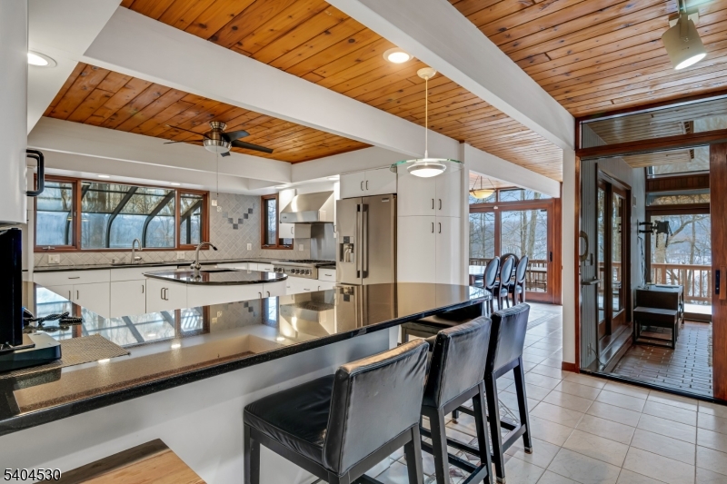 39 Woodland Road Morristown, NJ 07960 - Photo 11 of 34 a room with stainless steel appliances kitchen island granite countertop a table chairs and wooden cabinets
