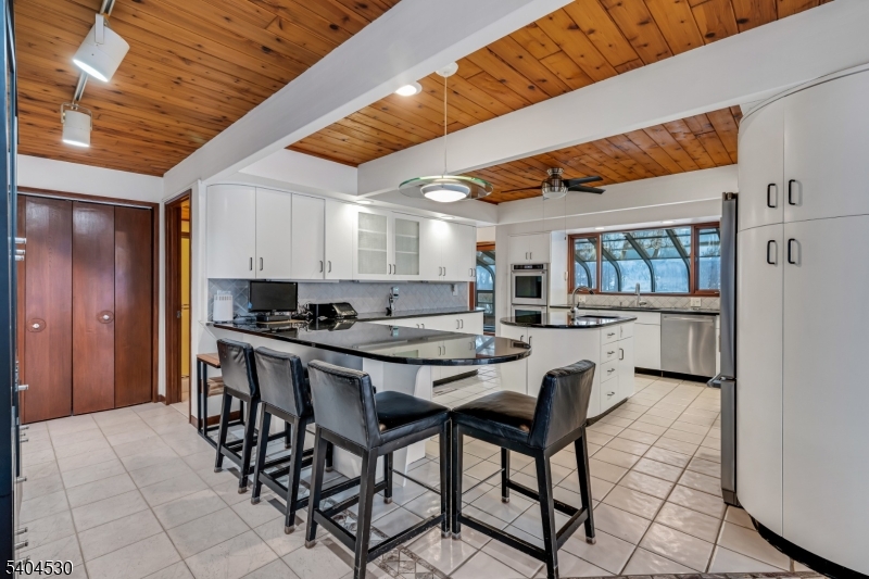 39 Woodland Road Morristown, NJ 07960 - Photo 13 of 34 a kitchen with stainless steel appliances kitchen island granite countertop a table chairs sink and cabinets