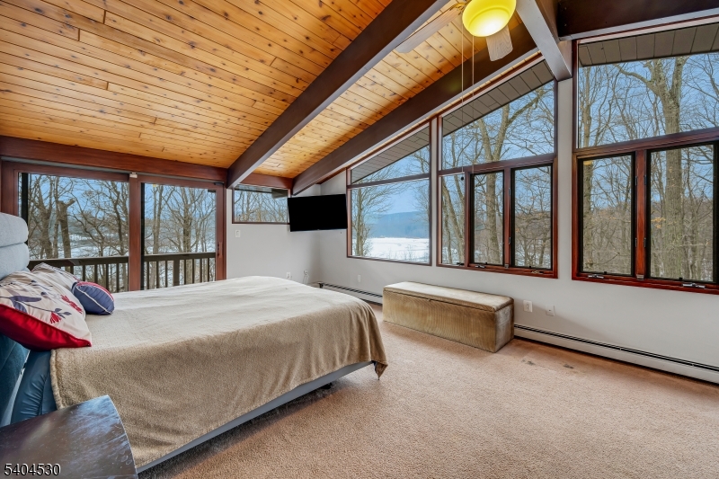 39 Woodland Road Morristown, NJ 07960 - Photo 19 of 34 a spacious bedroom with a large bed and a large window with balcony view