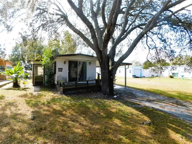 a view of a house with backyard and trees