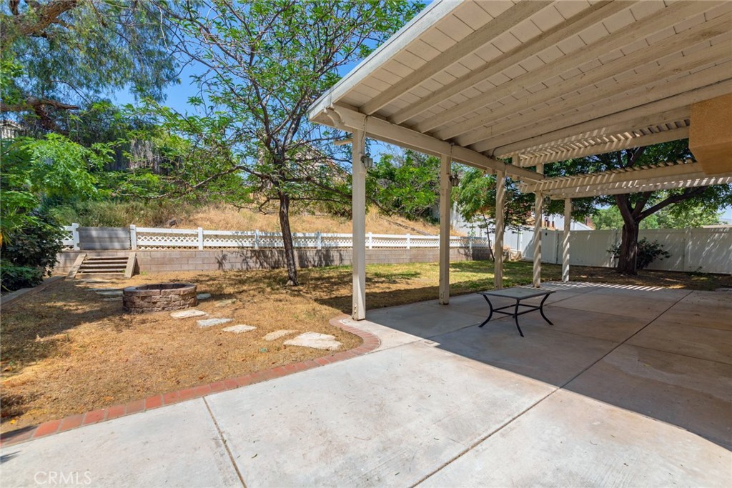 4179 Shellicia Circle Jurupa Valley, CA 92509 - Photo 25 of 25 a view of a patio with table and chairs under an umbrella with a large tree