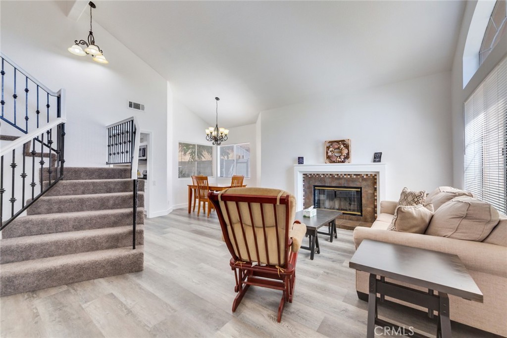 4179 Shellicia Circle Jurupa Valley, CA 92509 - Photo 4 of 25 a living room with furniture a fireplace and a chandelier