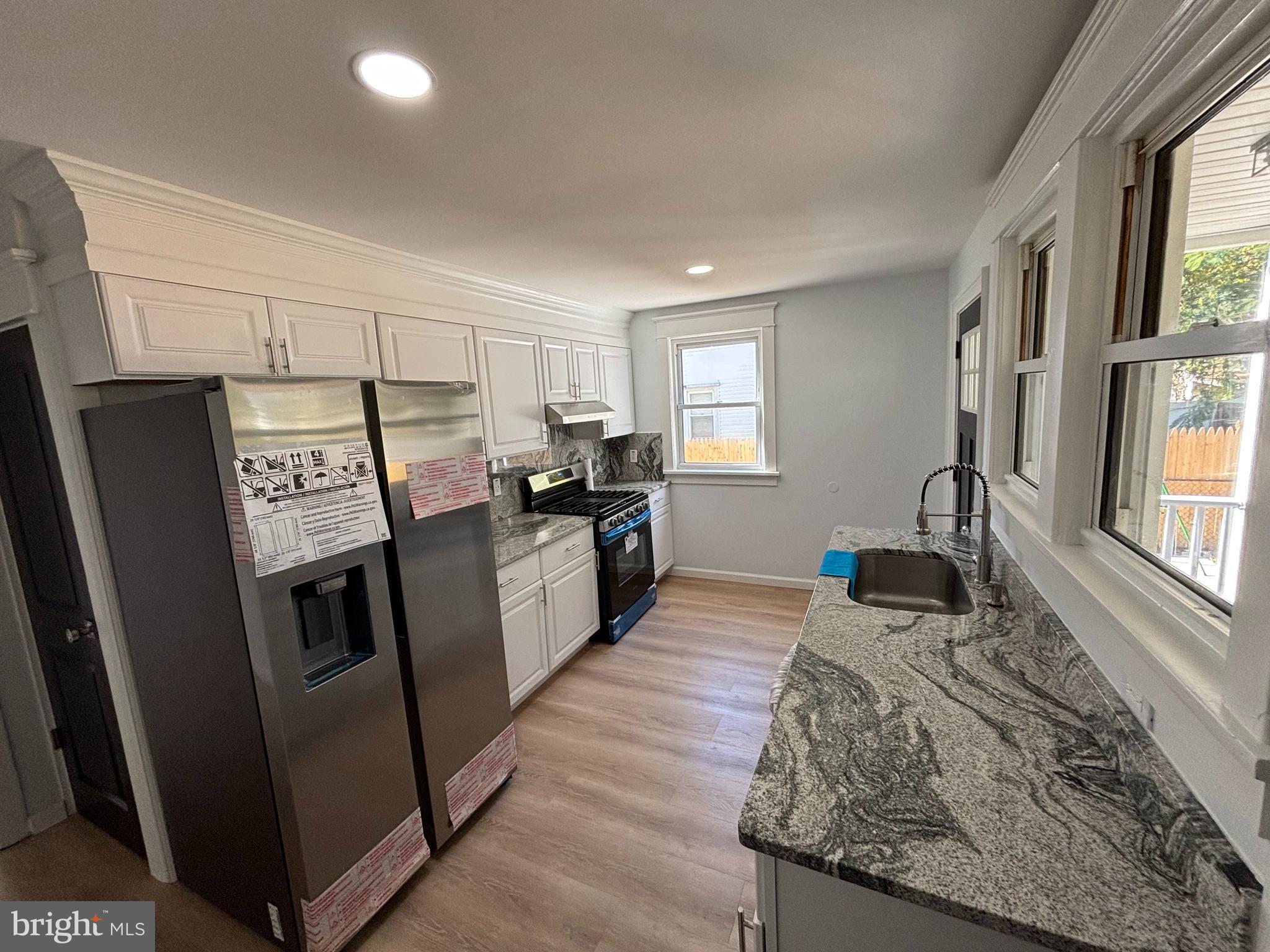 59 Pine Street Beverly, NJ 08010 - Photo 11 of 25 a kitchen with granite countertop stainless steel appliances a counter top space and a window