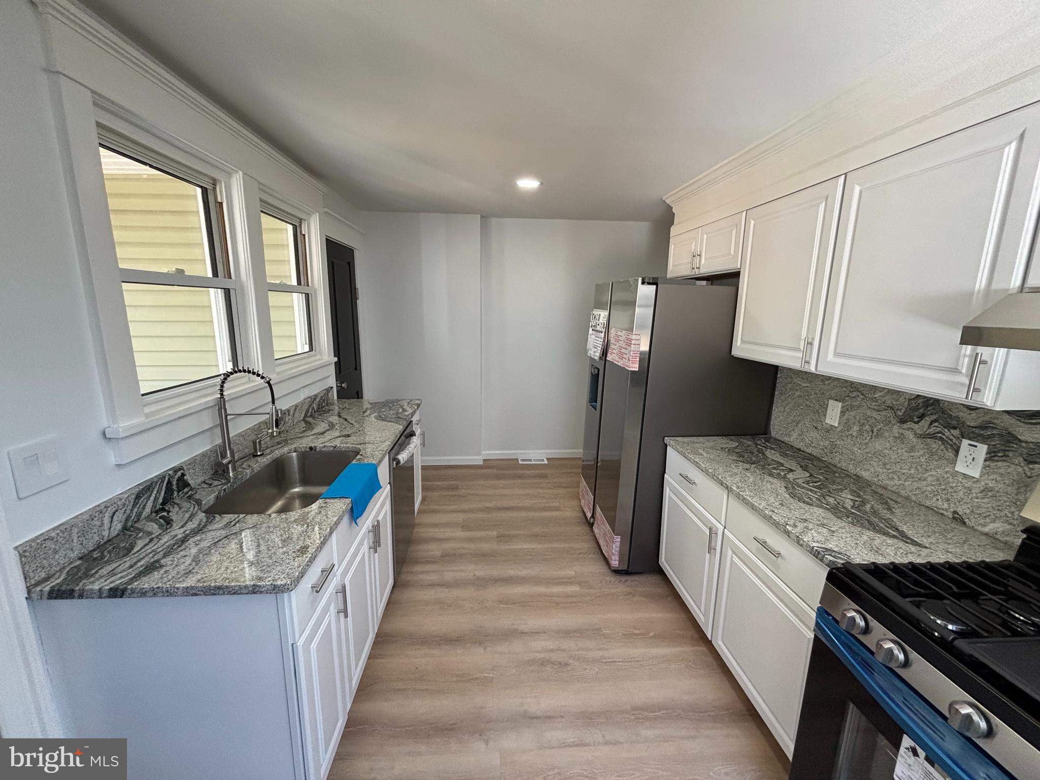59 Pine Street Beverly, NJ 08010 - Photo 7 of 25 a kitchen with granite countertop a sink stove and refrigerator