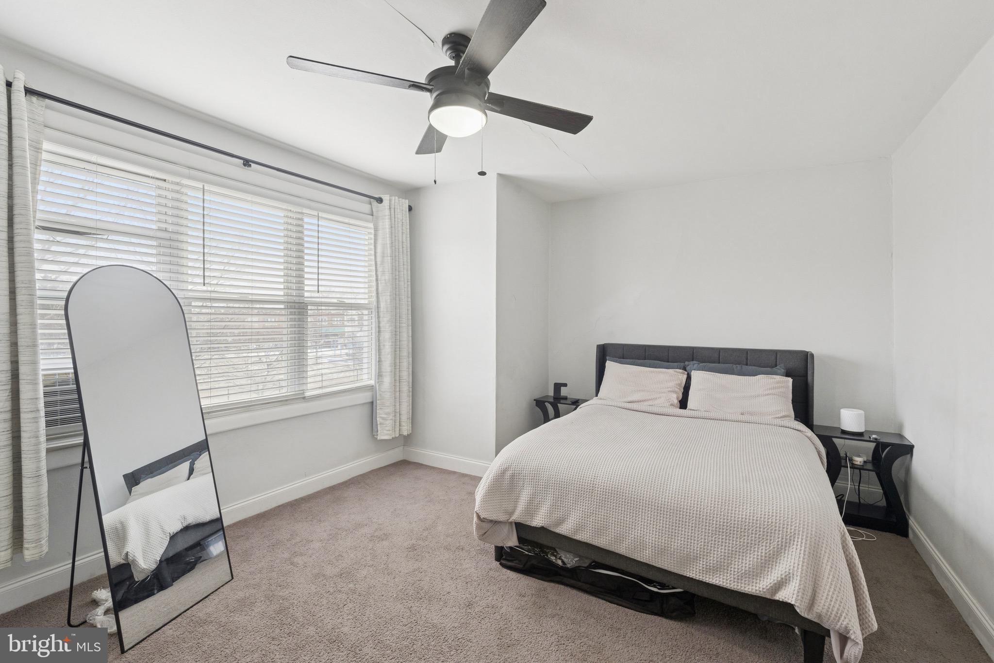 6532 Hegerman Street Philadelphia, PA 19135 - Photo 11 of 25 a spacious bedroom with a bed a chair and a large window
