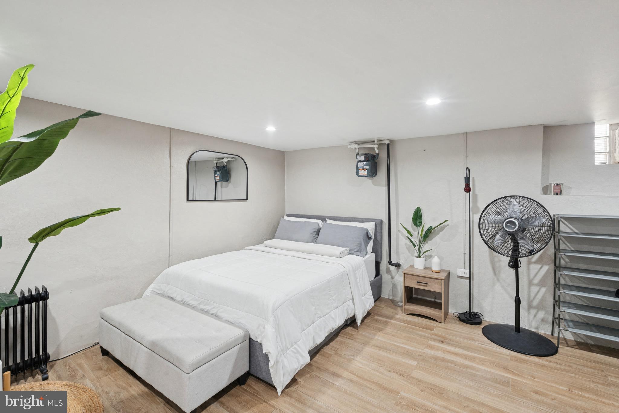 6532 Hegerman Street Philadelphia, PA 19135 - Photo 22 of 25 a spacious bedroom with a bed a table and painting on the wall