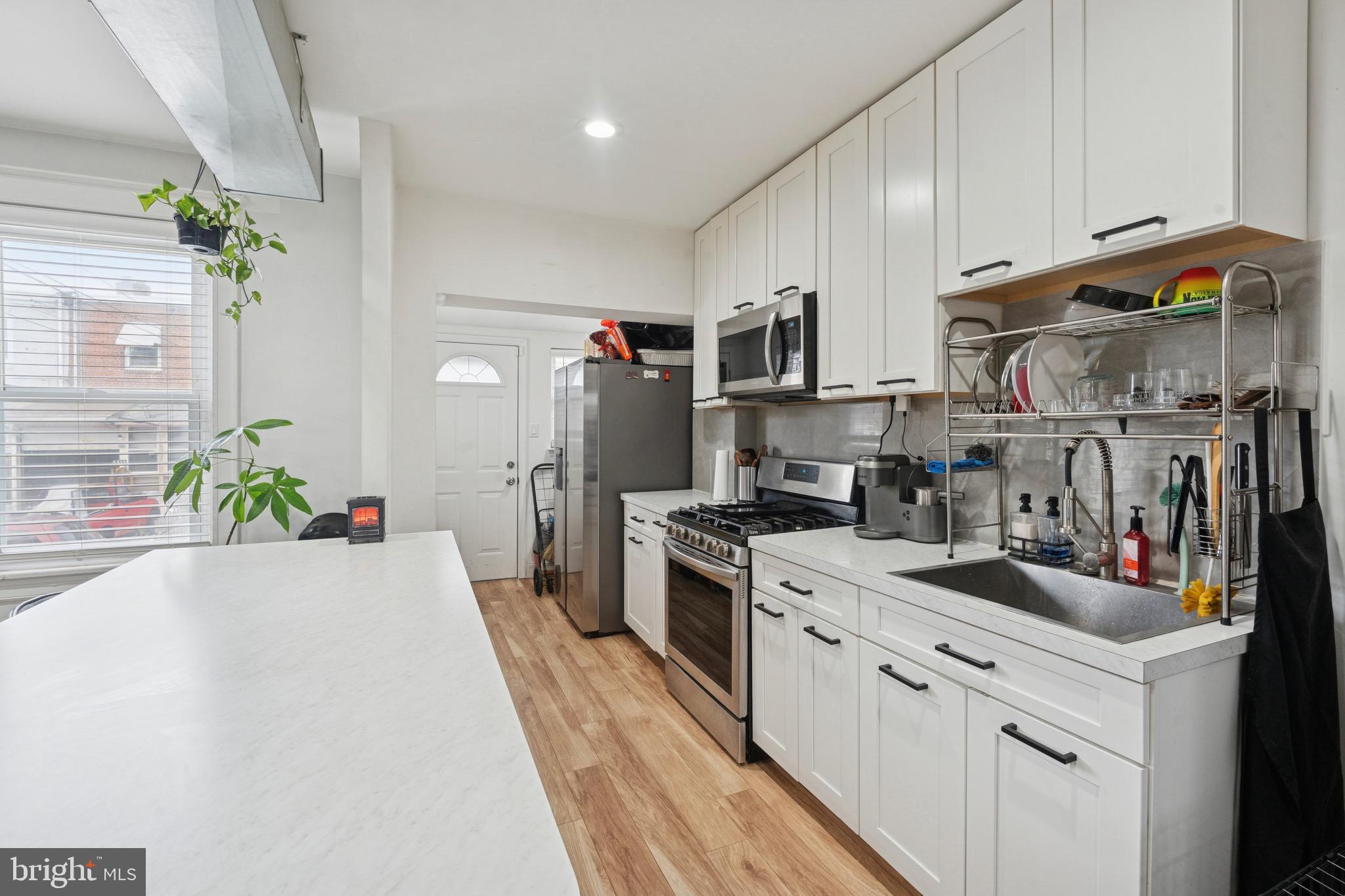6532 Hegerman Street Philadelphia, PA 19135 - Photo 9 of 25 a kitchen with granite countertop a sink stainless steel appliances and cabinets