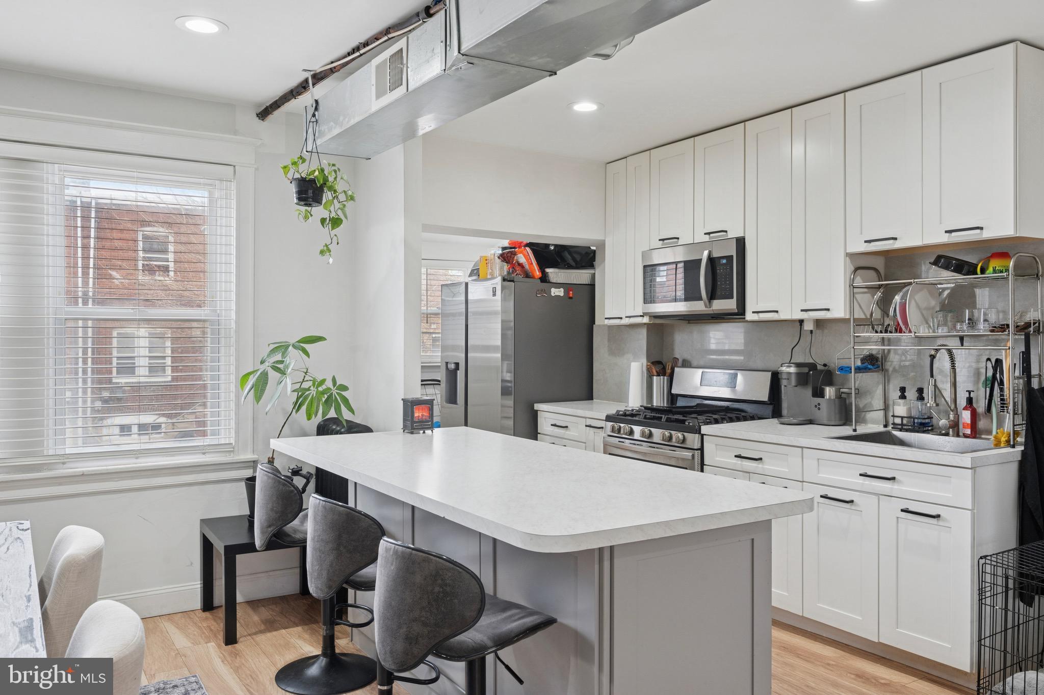6532 Hegerman Street Philadelphia, PA 19135 - Photo 10 of 25 a kitchen with stainless steel appliances a sink a table and chairs in it