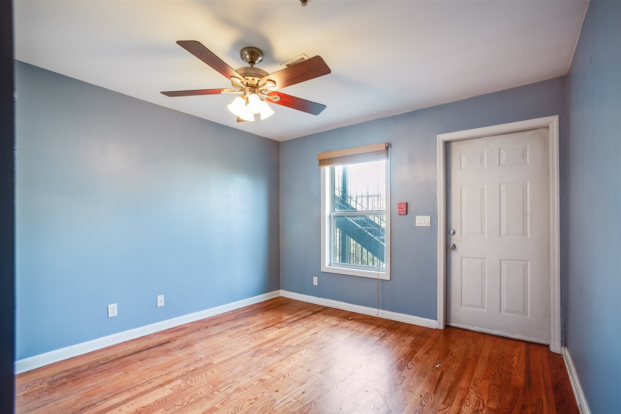 80 Madison Street, Unit 4 Hoboken, NJ 07030 - Photo 12 of 19 an empty room with wooden floor fan and windows