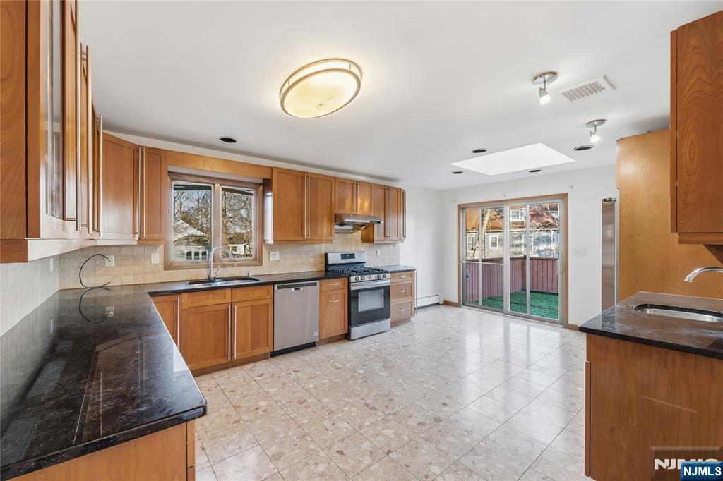 325 High Street Closter, NJ 07624 - Photo 6 of 34 a kitchen with stainless steel appliances granite countertop a sink stove and refrigerator