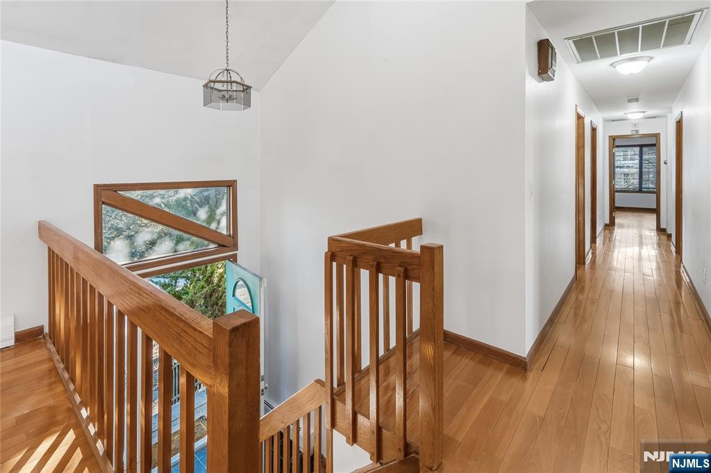 325 High Street Closter, NJ 07624 - Photo 7 of 34 a view of a hallway with wooden floor and stairs