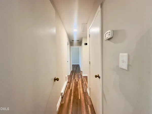a view of a hallway with wooden floor