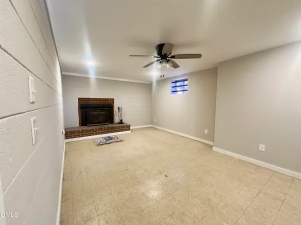 a view of a livingroom with a flat screen tv a ceiling fan and refrigerator